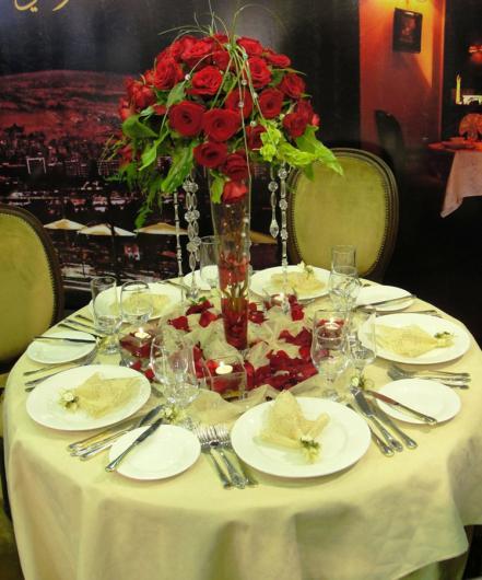 تنسيق الورود، وترتيب الطاولات والصحون في معرض الأعراس