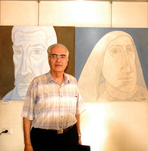 التشكيلي نعيم شلش مع لوحته في المعرض